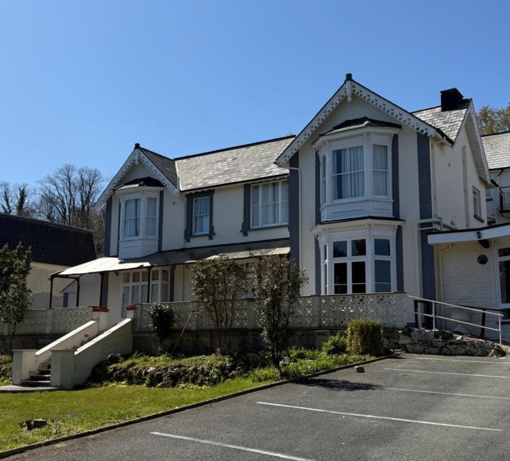 The Queens Road Hotel exterior with Victorian gables, bay windows, and parking area in Shanklin
